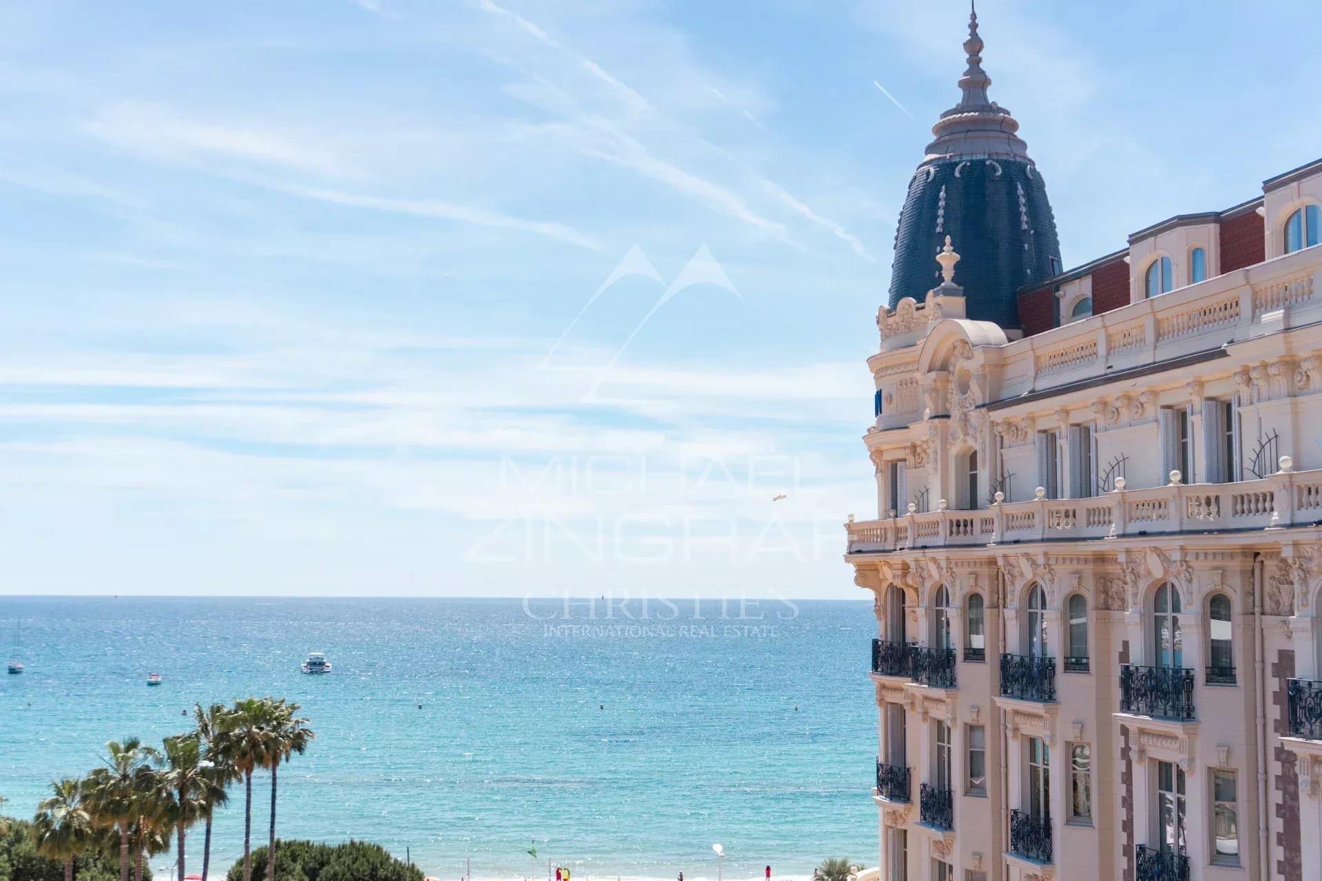 Sea view from a building in Cannes, with palm trees in the foreground.
