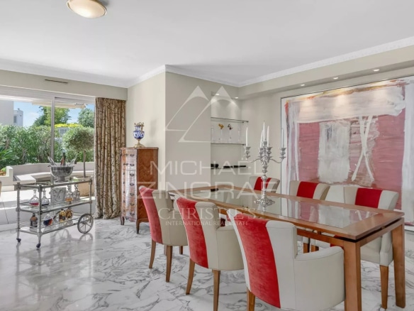 Dining room of a penthouse in Cannes with elegant furniture and access to a terrace.