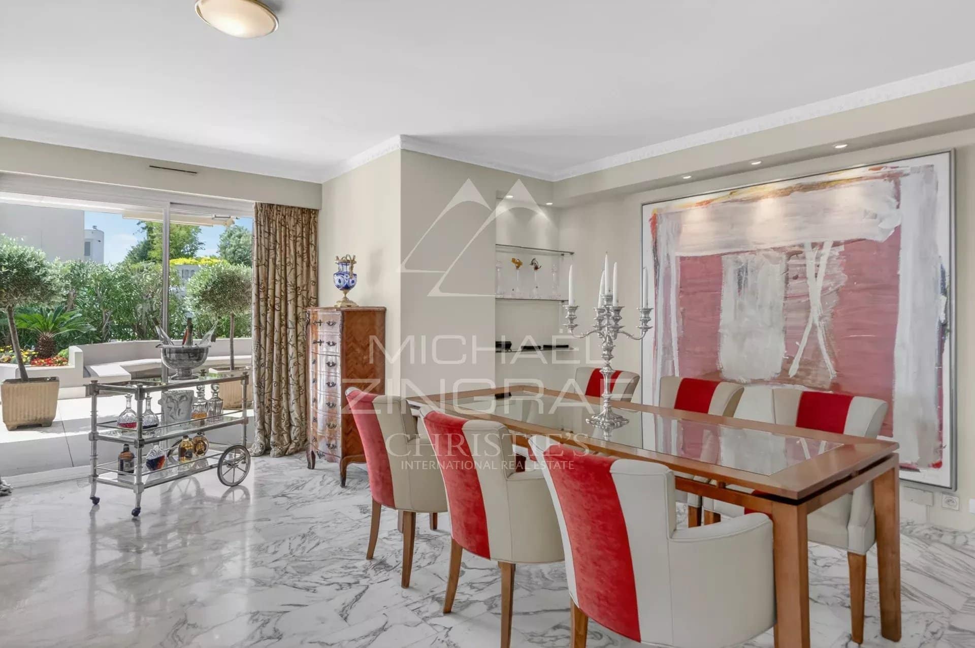 Dining room of a penthouse in Cannes with elegant furniture and access to a terrace.