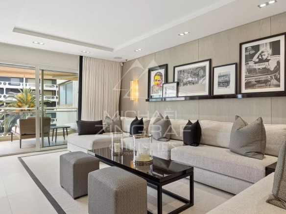 Modern living room of an apartment in Cannes, with sofa, coffee table and access to a balcony.