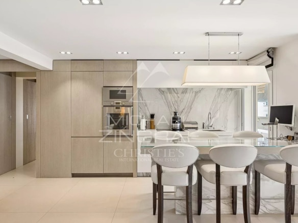 Modern and elegant kitchen in an apartment in Cannes, with a marble worktop and light-colored furniture.