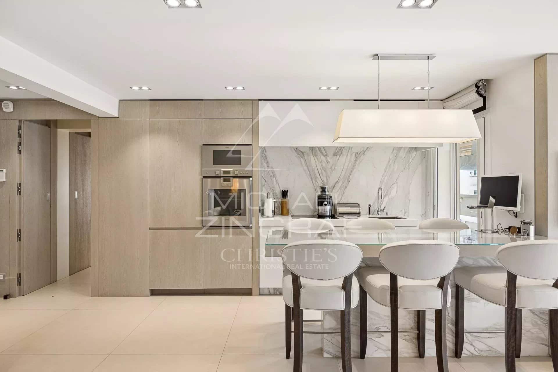 Kitchen of an exceptional apartment in Cannes Modern and elegant kitchen in an apartment in Cannes, with a marble worktop and light-colored furniture.
