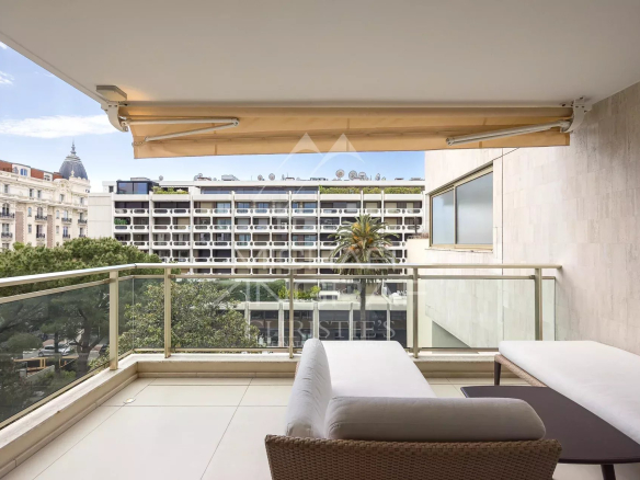 Balcony of an apartment in Cannes with views of buildings and trees.