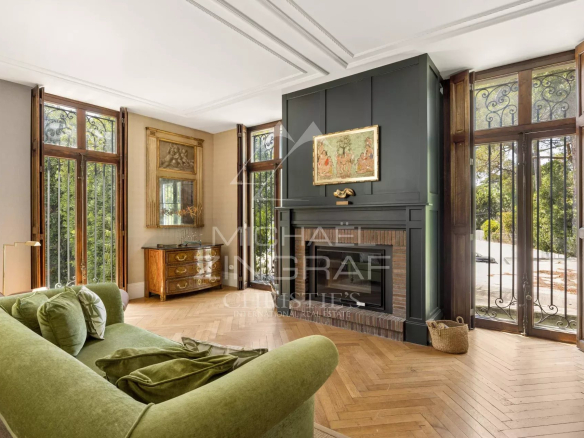 Intérieur d'une maison élégante avec un salon lumineux et un canapé vert, fenêtres en bois.