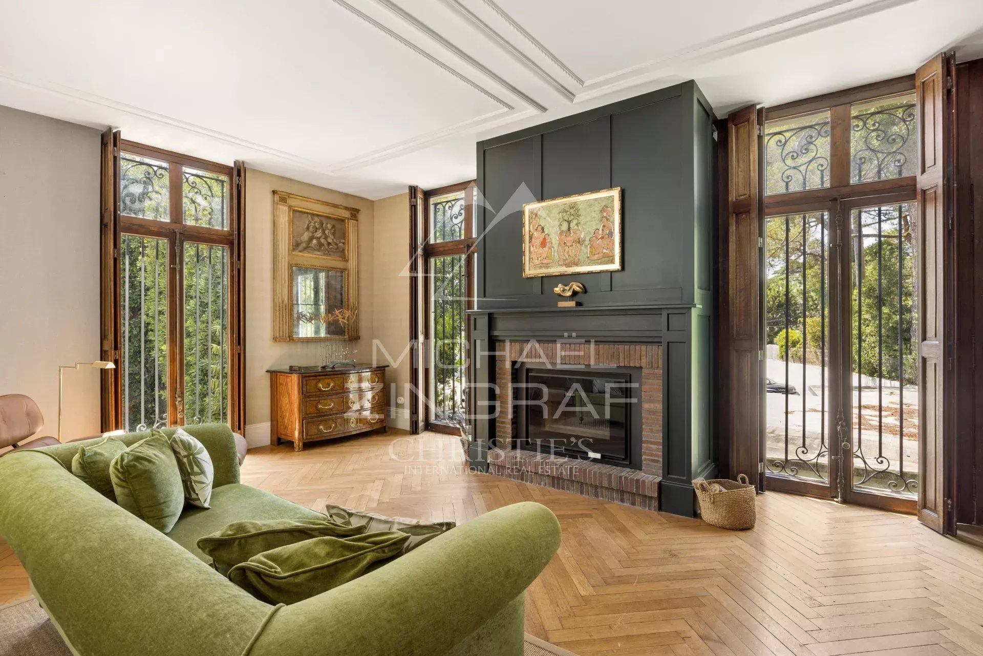 Intérieur d'une maison élégante avec un salon lumineux et un canapé vert, fenêtres en bois.