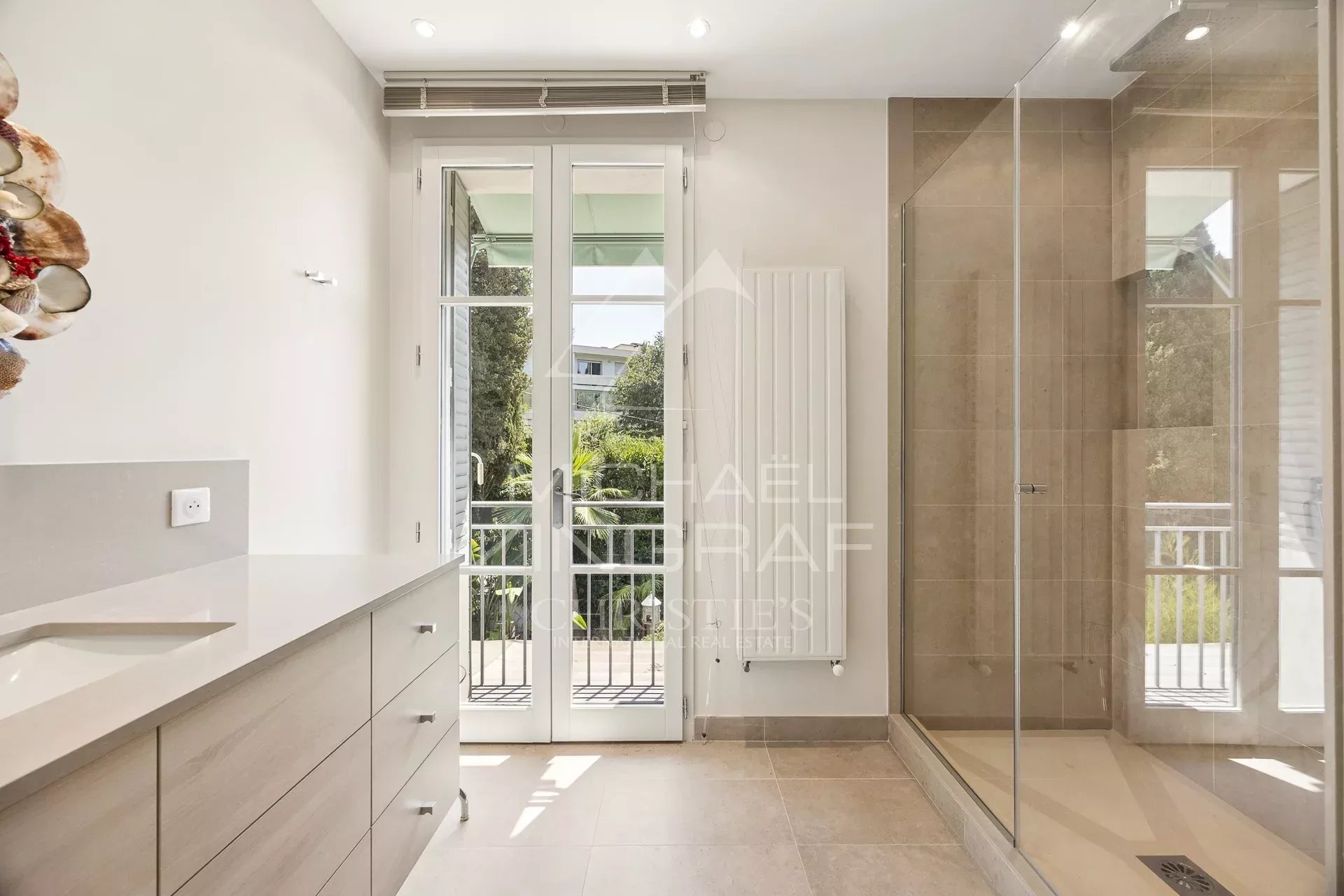 Salle de bain lumineuse avec douche et vue sur le jardin, maison à Cannes Basse Californie.