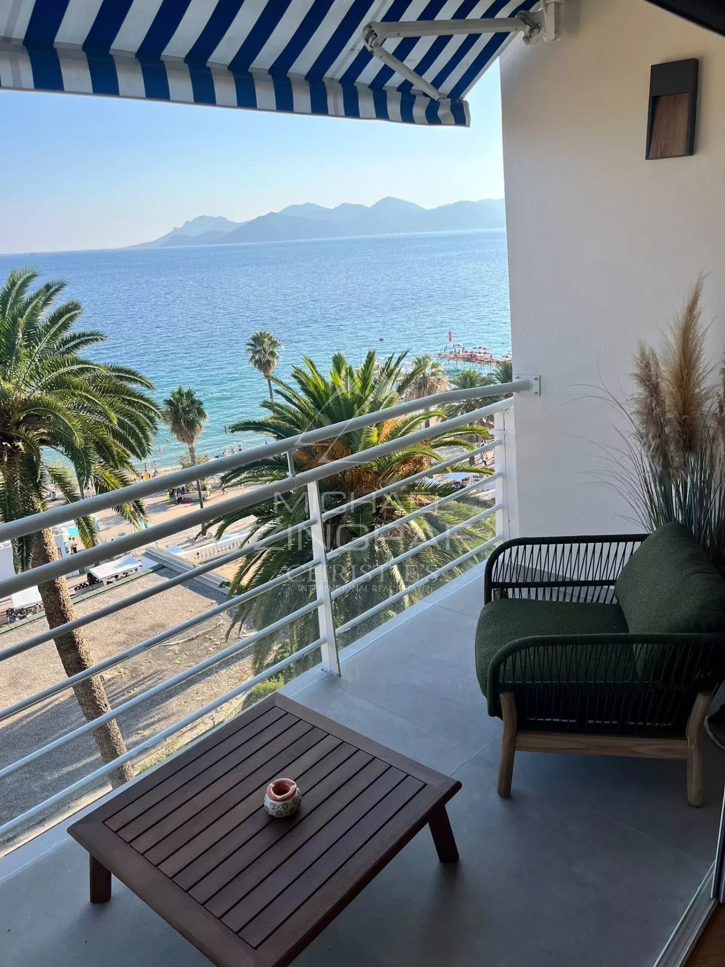 Balcony of an apartment with sea and palm tree views in Cannes.