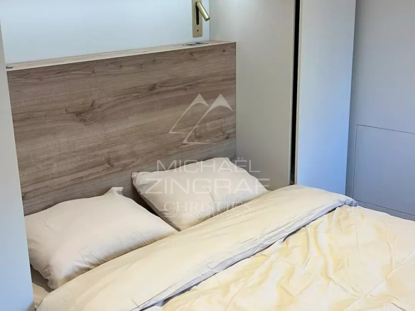 Room in a renovated apartment with a double bed and built-in storage.