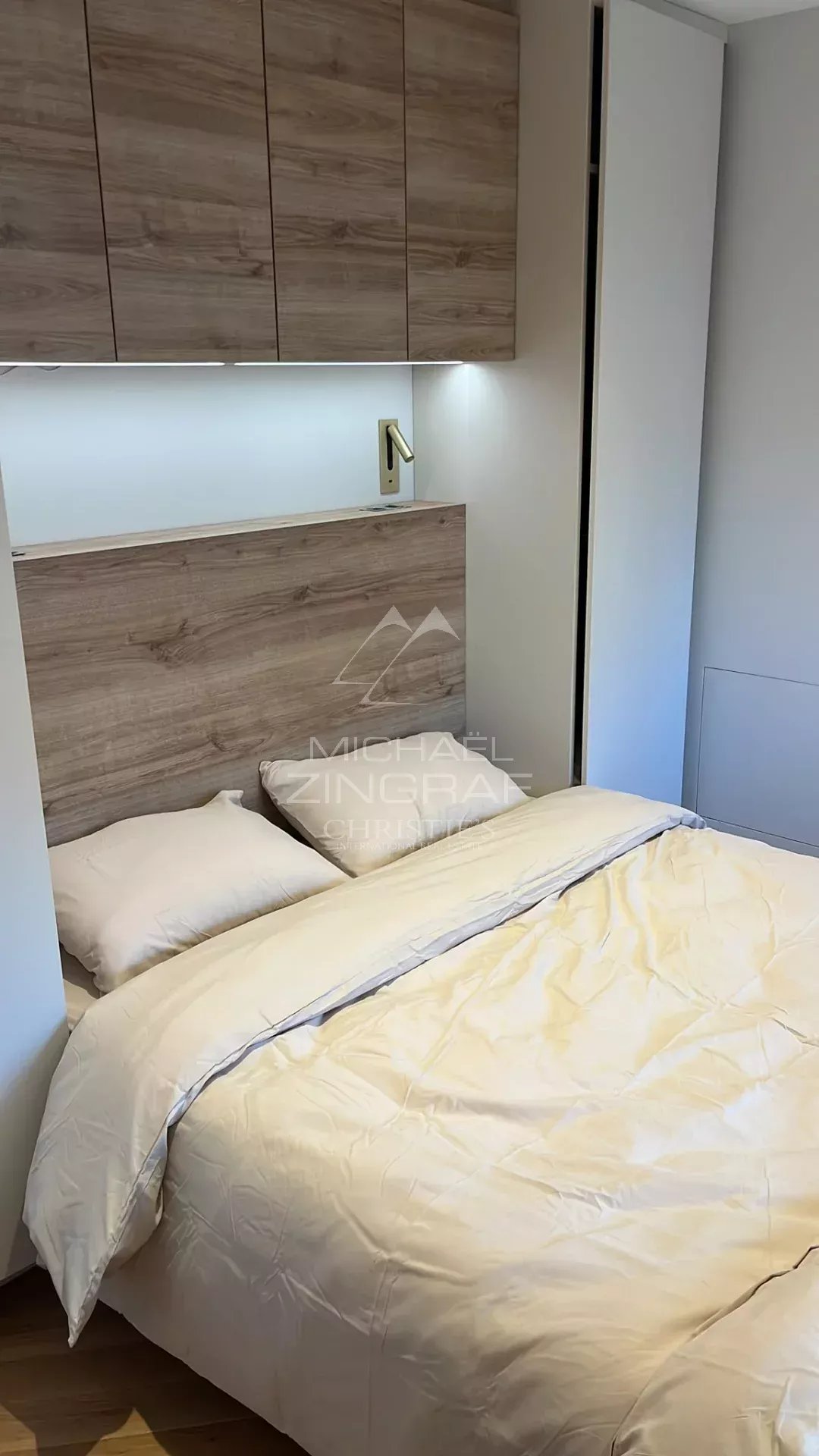 Room in a renovated apartment with a double bed and built-in storage.