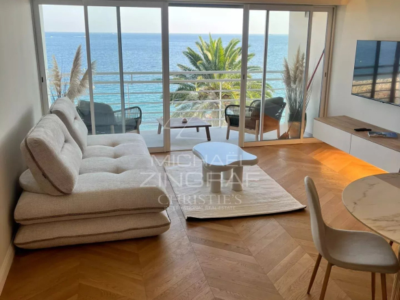 Interior of a renovated apartment with sea view in Cannes, bright and modern living room.