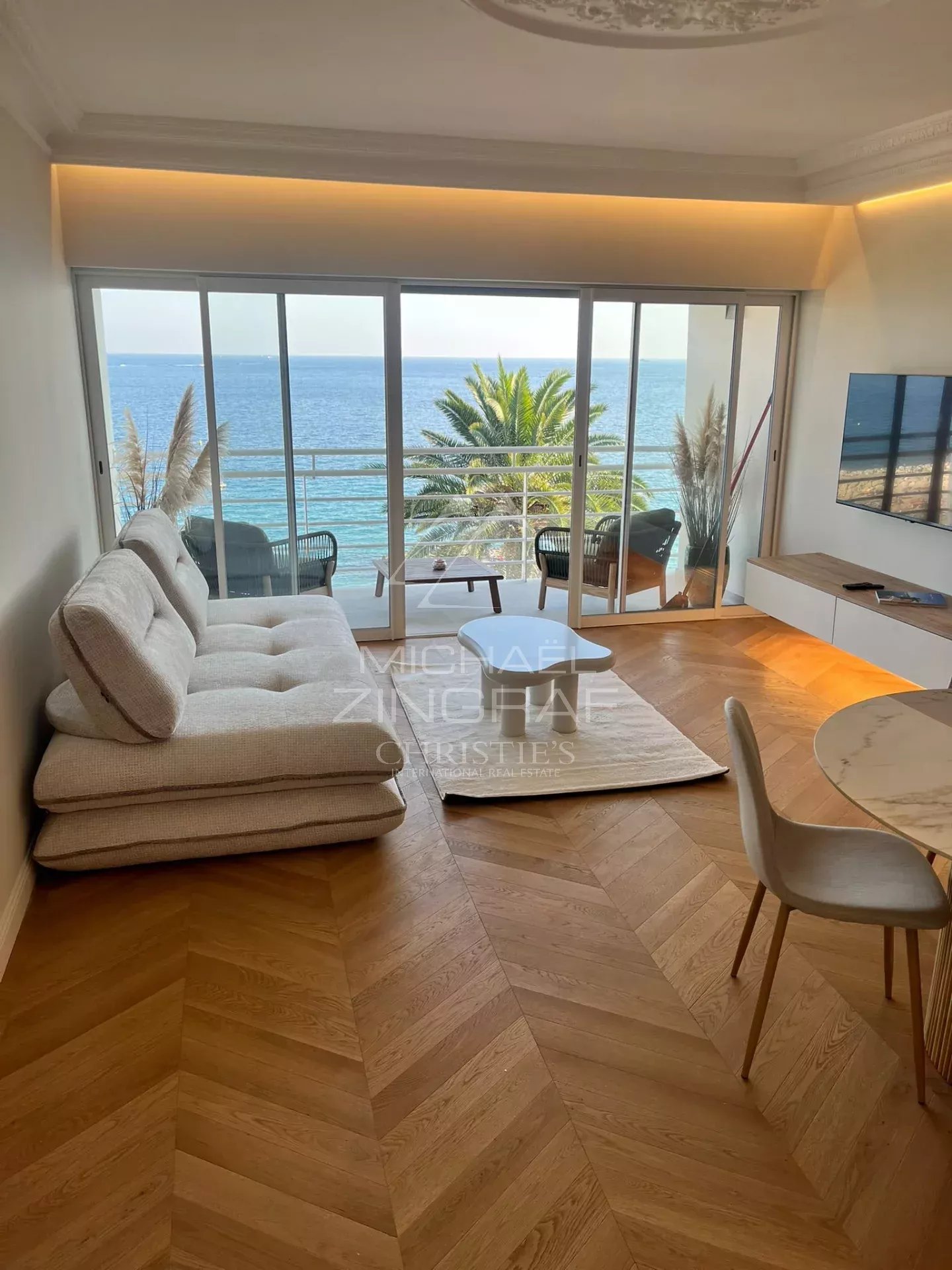Interior of a renovated apartment with sea view in Cannes, bright and modern living room.