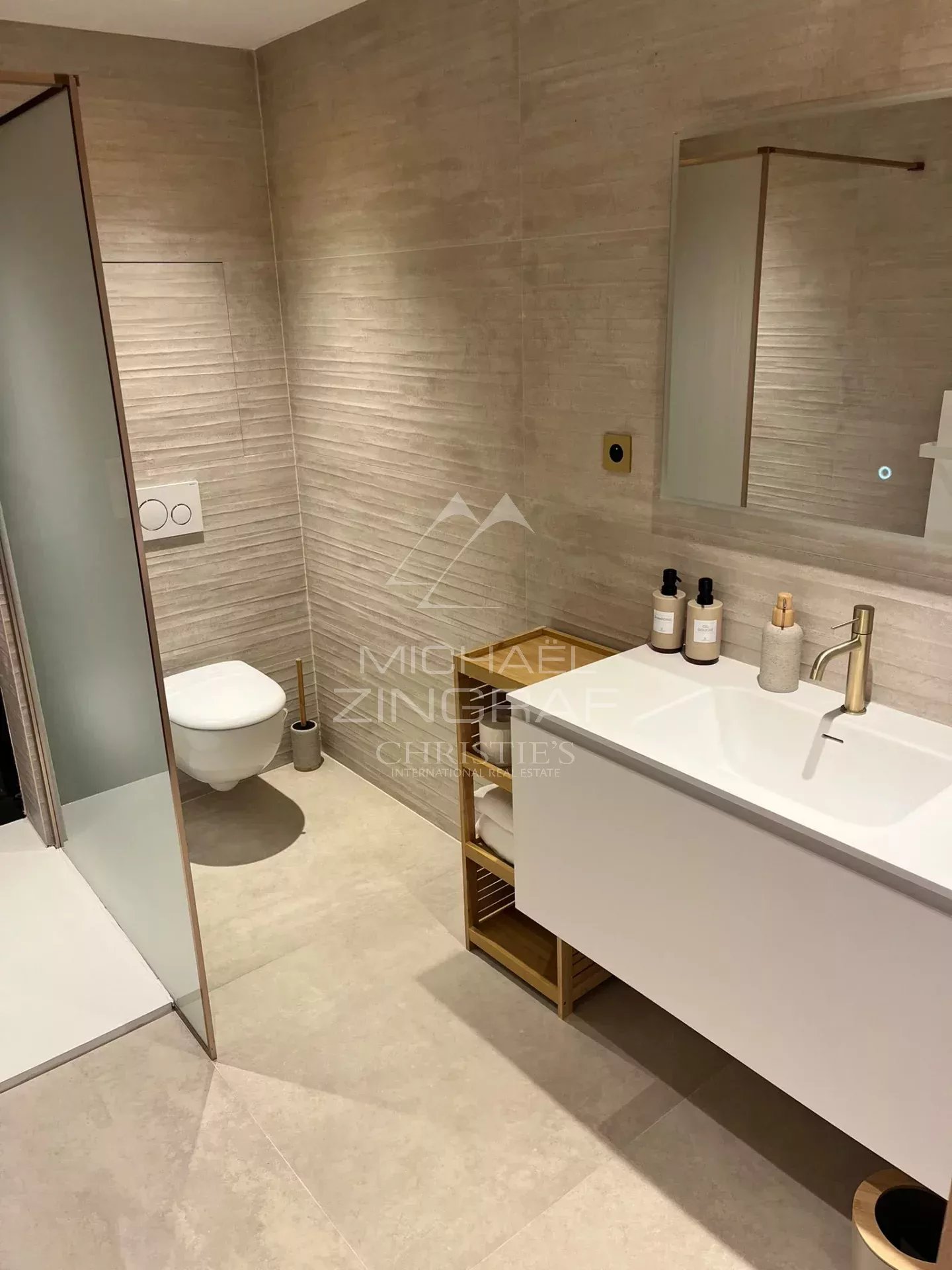 Modern bathroom with shower, sink and toilet in a renovated apartment in Cannes.