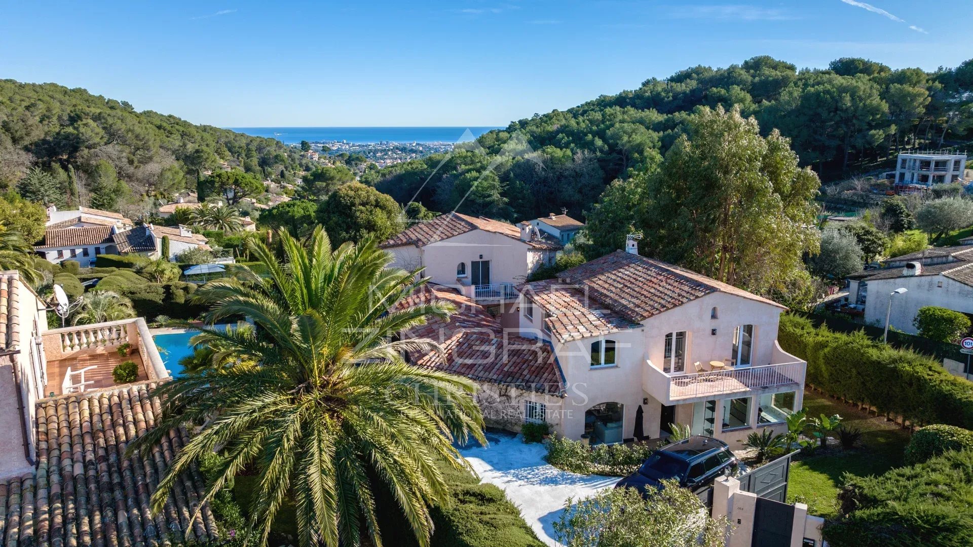 Renovated family property with swimming pool in the hills above Cannes, surrounded by greenery.