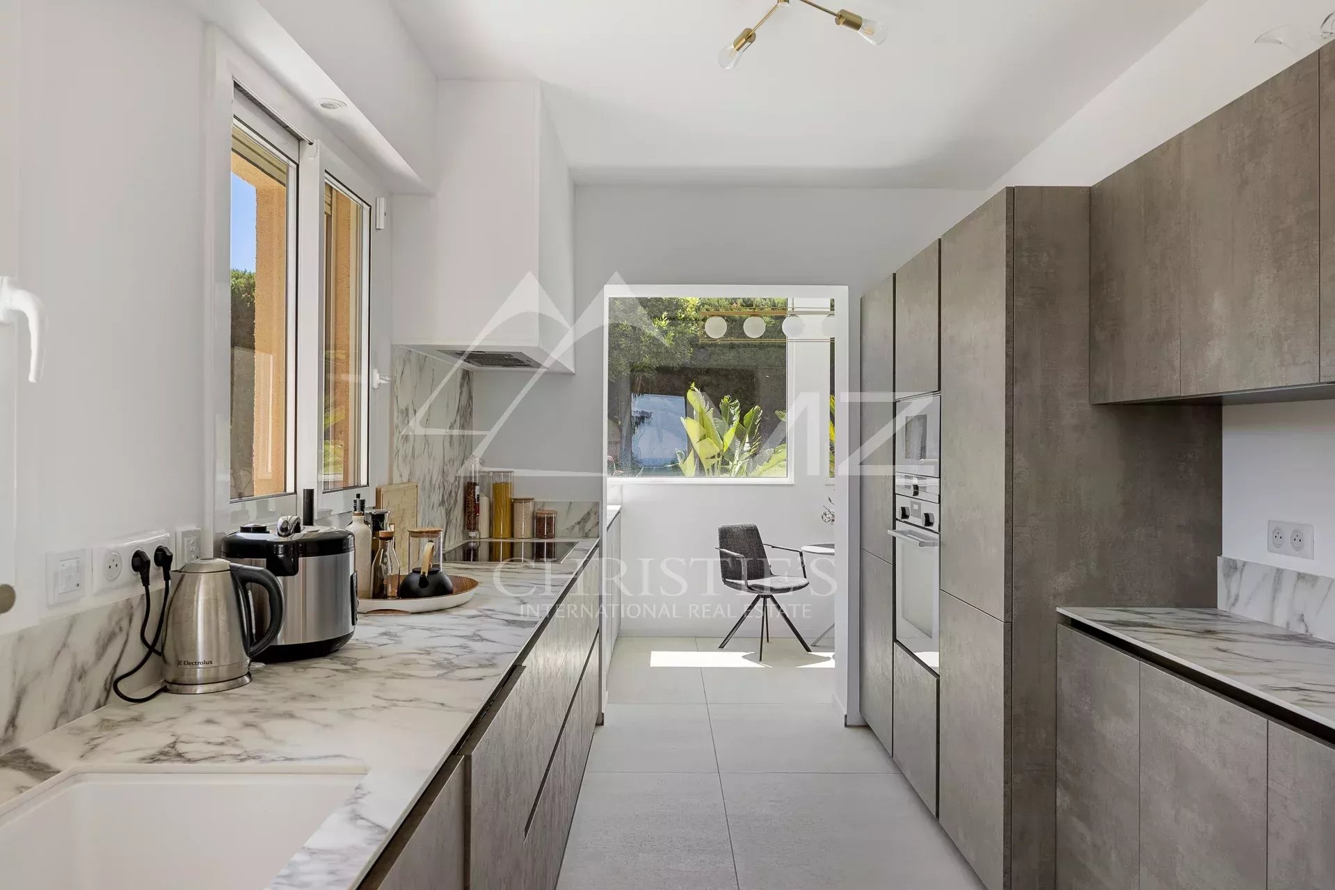 Modern and bright kitchen with marble worktops and access to the outside.
