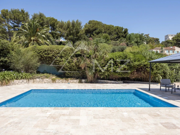 Swimming pool of a renovated family property in Vallauris, surrounded by greenery.