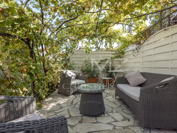 Terrasse d'une villa bourgeoise avec mobilier en osier et plantes, Cannes Petit Juas.