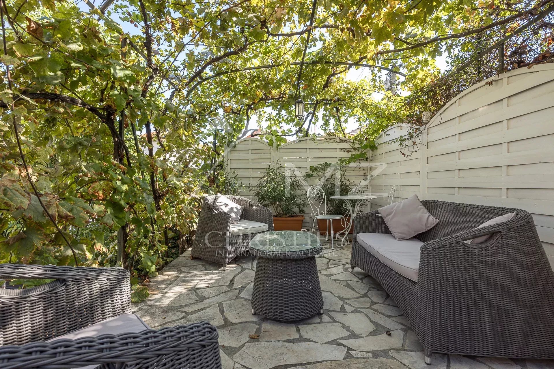 Terrasse de villa à Cannes Terrasse d'une villa bourgeoise avec mobilier en osier et plantes, Cannes Petit Juas.