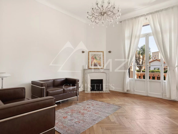 Intérieur d'une maison bourgeoise à Cannes, salon avec canapé et cheminée.