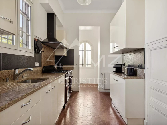Cuisine moderne dans une villa bourgeoise à Cannes, avec plans de travail en granit et équipements intégrés.
