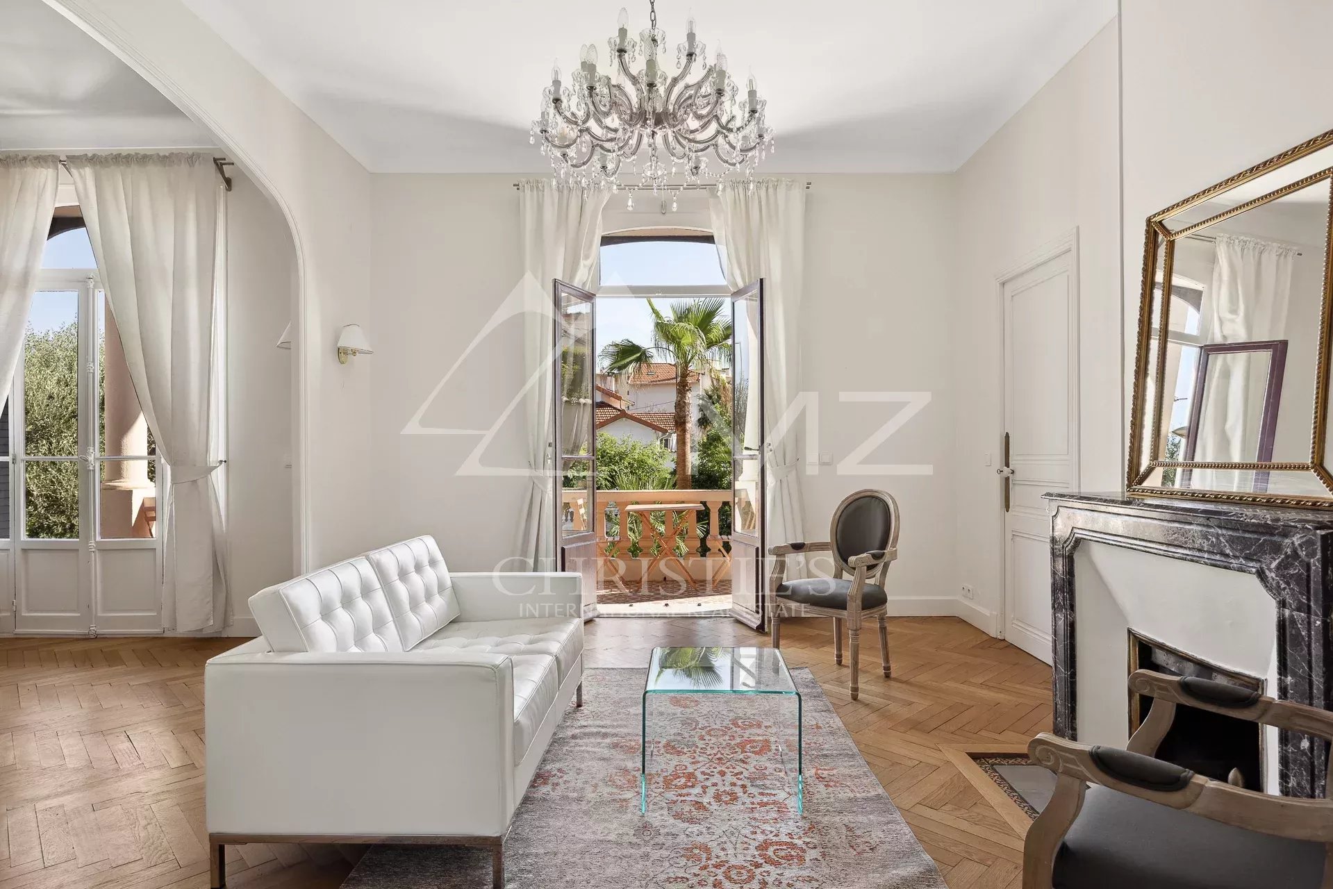Salon d’une maison bourgeoise à Cannes Intérieur d'une maison bourgeoise à Cannes, avec un salon lumineux et des fenêtres ouvertes sur l'extérieur.
