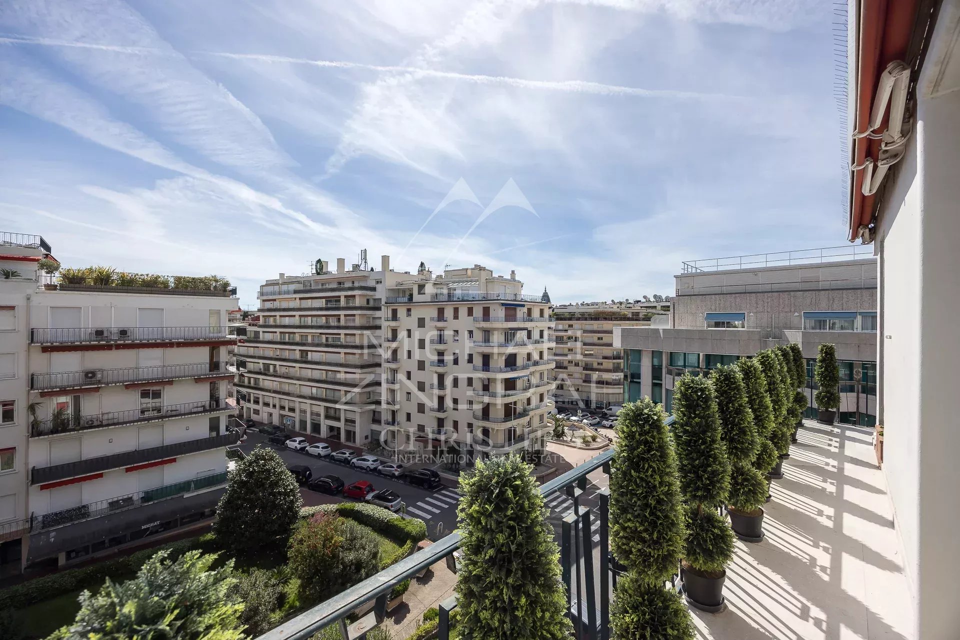 Terrasse d’un appartement à Cannes Vue depuis une terrasse d'un appartement à Cannes, montrant des bâtiments environnants et un ciel dégagé.