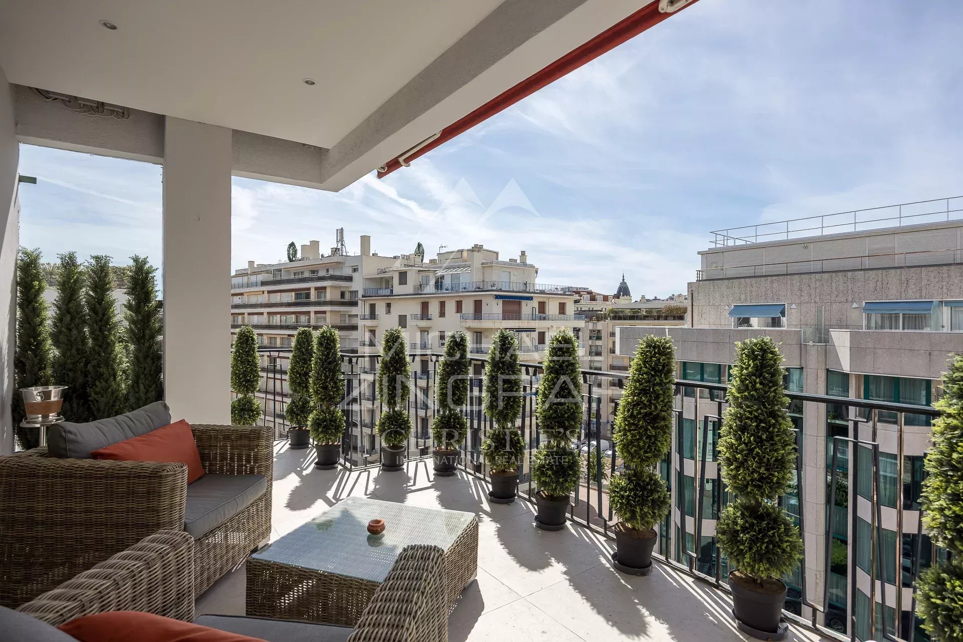 Terrasse d’un appartement rénové à Cannes Terrasse d'un appartement à Cannes avec vue sur la ville et des plantes en pot.