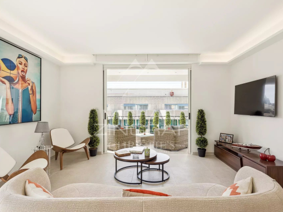 Salon lumineux d'un appartement rénové à Cannes avec terrasse et décoration moderne.