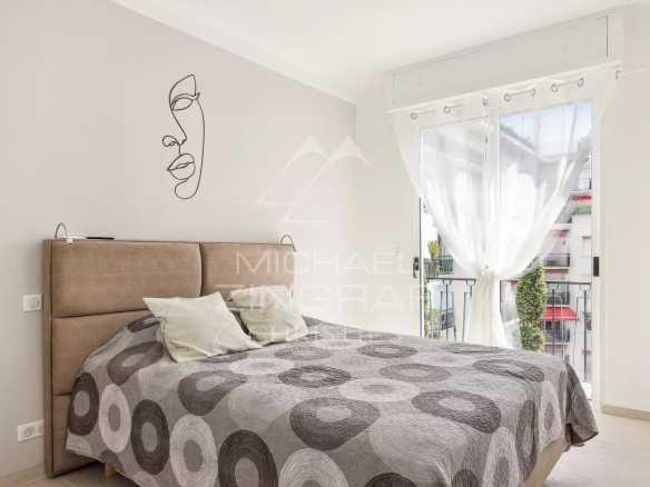Chambre d'un appartement rénové à Cannes avec un lit et une décoration moderne.