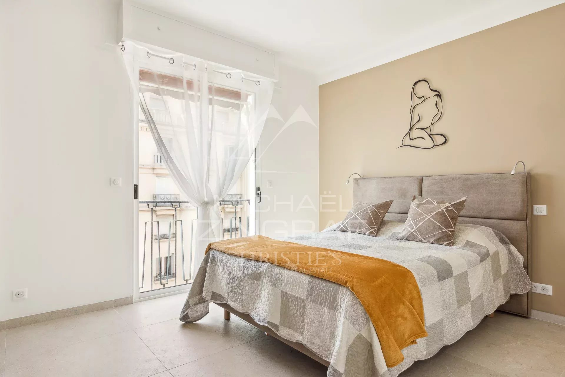 Chambre d’appartement à Cannes Chambre d'un appartement rénové à Cannes avec un lit double et un balcon.