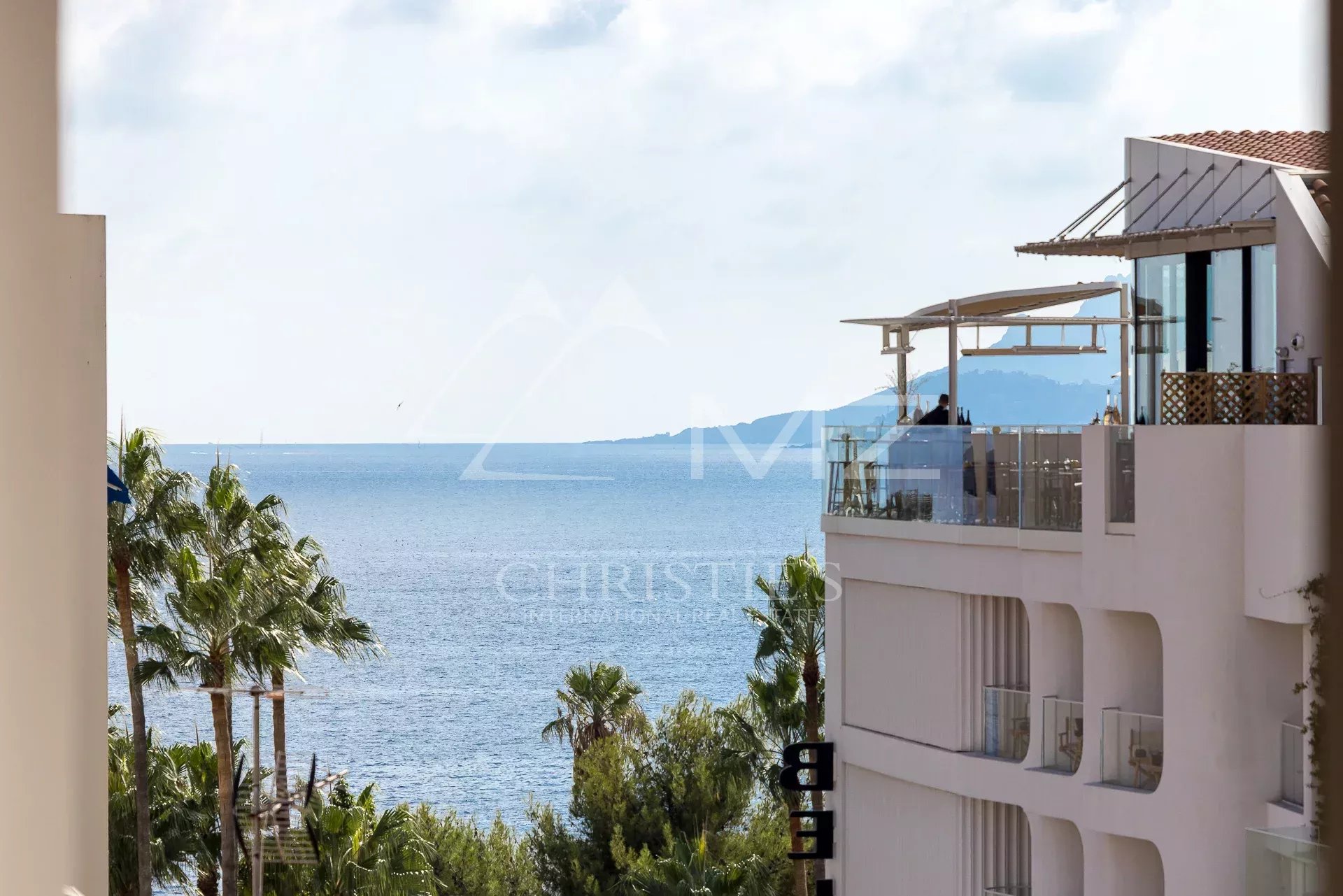 Vue mer depuis un appartement à Cannes Vue mer depuis un appartement à Cannes avec palmiers au premier plan.