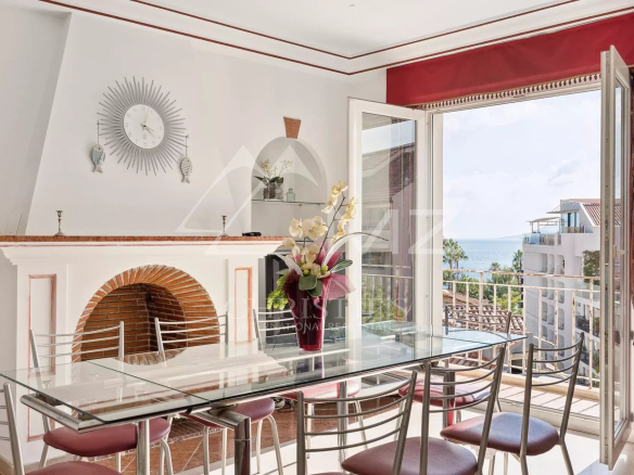 Intérieur d'un appartement lumineux avec vue sur la mer, salle à manger et balcon à Cannes.