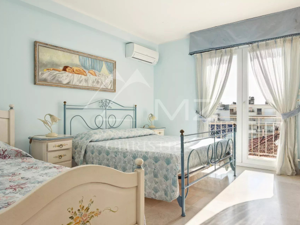 Chambre d'un appartement à Cannes avec lits simples et balcon.