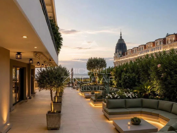 Spacious terrace with views of the sea and the Carlton in Cannes, modern furniture and greenery.