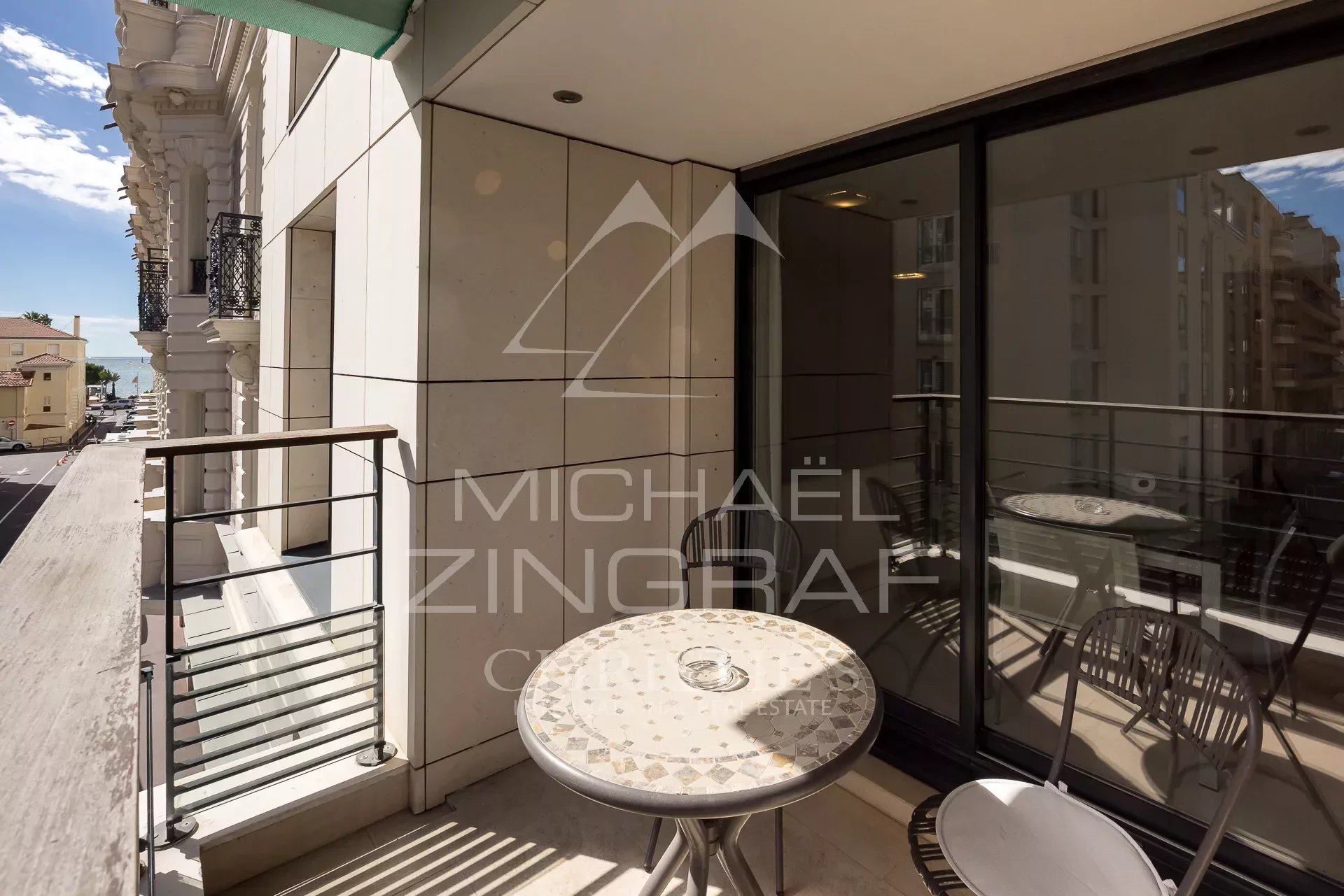 Terrasse d’appartement à Cannes Terrasse d'un appartement 2 pièces à Cannes avec table et chaises, vue sur la rue.