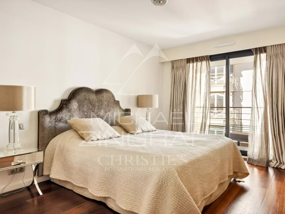 Bedroom in a contemporary apartment in Cannes with a double bed and light curtains.