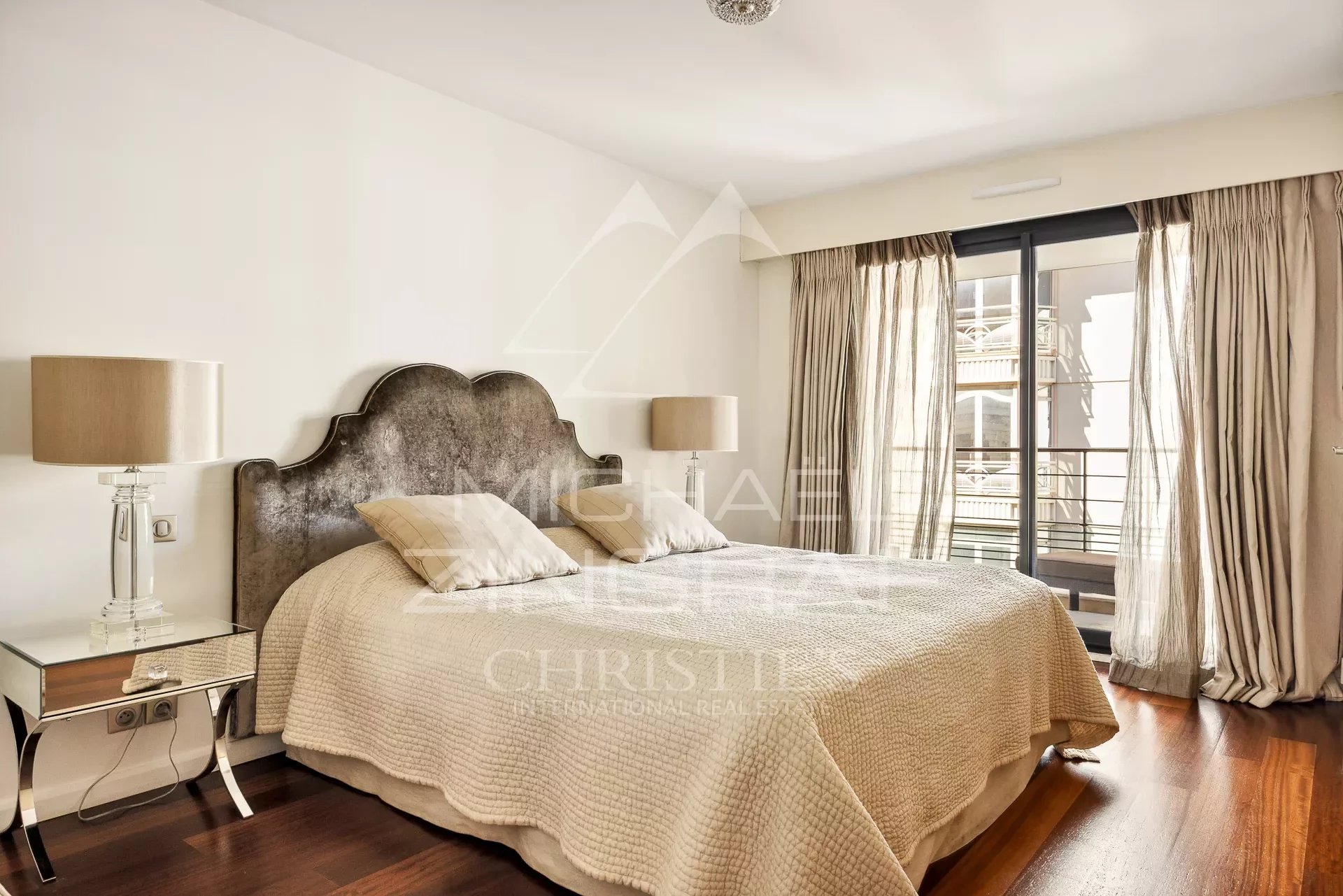 Apartment room in Cannes Bedroom in a contemporary apartment in Cannes with a double bed and light curtains.