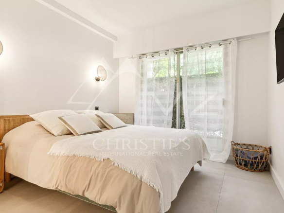 Chambre lumineuse avec lit double et accès à une terrasse, décoration minimaliste.