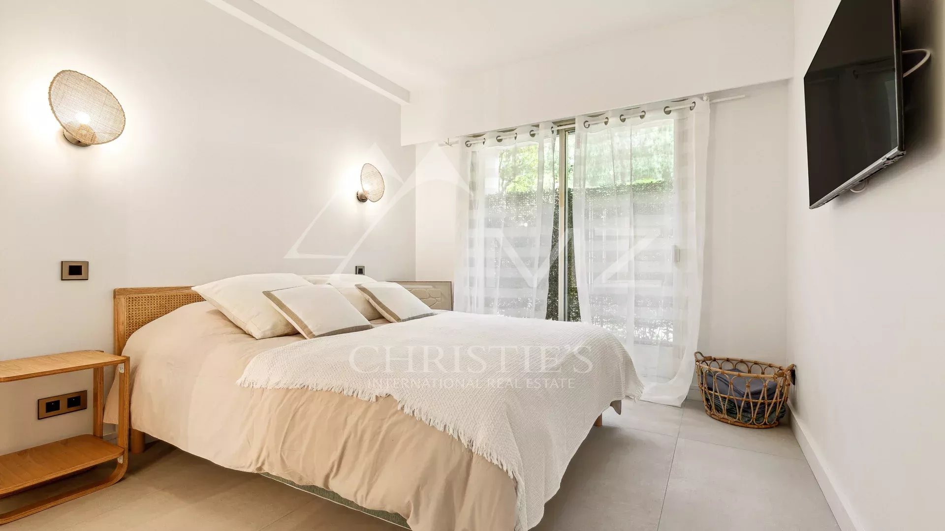 Chambre lumineuse avec lit double et accès à une terrasse, décoration minimaliste.