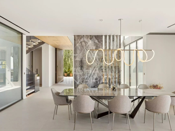 Intérieur d'une villa contemporaine avec salle à manger moderne et vue sur la mer.