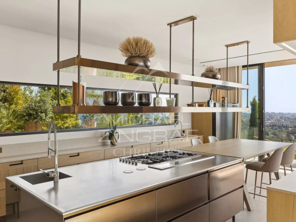 Cuisine moderne avec îlot central et vue sur la mer, à l'intérieur d'une villa contemporaine à Cannes.