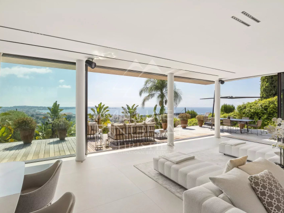 Intérieur moderne d'une villa à Cannes avec vue sur la mer et le jardin.