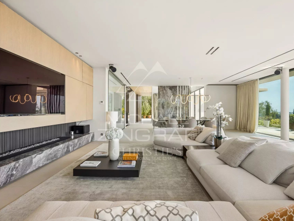 Intérieur d'une villa contemporaine avec salon lumineux et télévision murale.