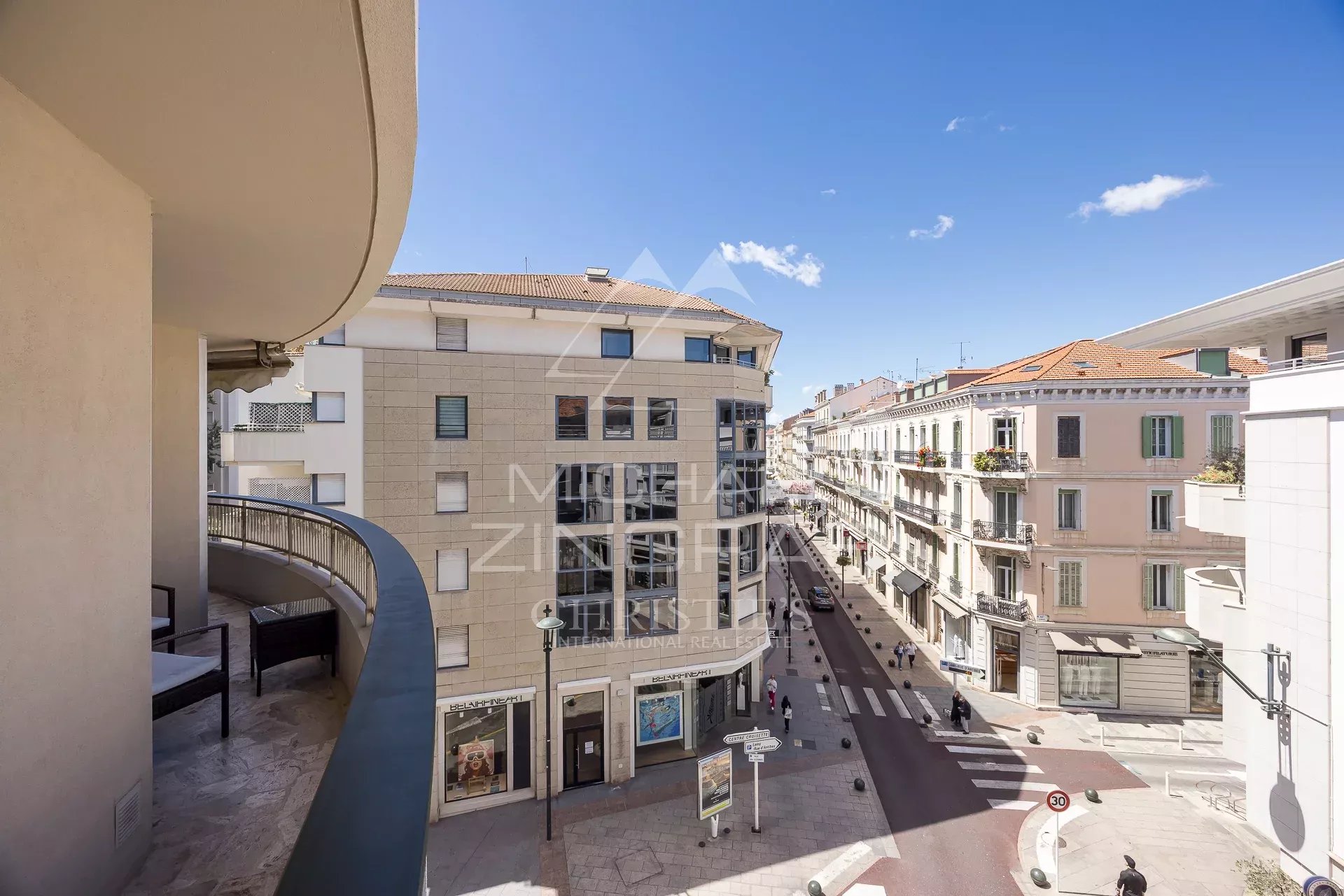 Vue depuis un appartement à Cannes Vue depuis un appartement à Cannes, montrant une rue animée et des bâtiments environnants.