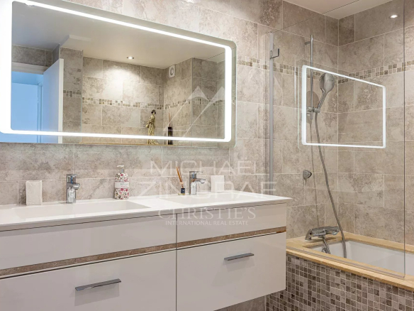 Salle de bain moderne avec carrelage et miroir lumineux dans un appartement à Cannes.