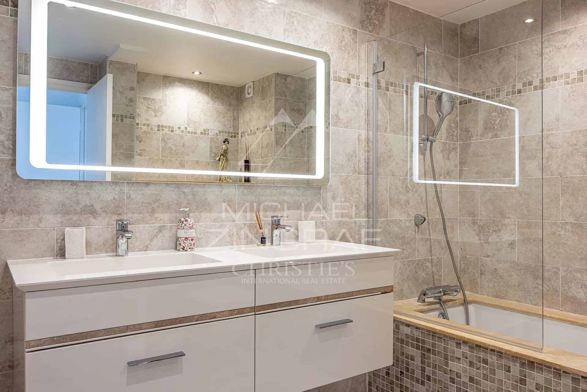Salle de bain élégante à Cannes Salle de bain moderne avec carrelage et miroir lumineux dans un appartement à Cannes.