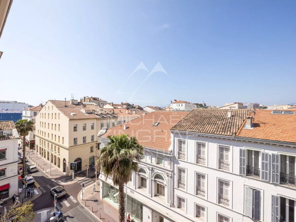 Vue depuis un appartement au 3ème étage à Cannes, montrant des bâtiments et des rues ensoleillées.