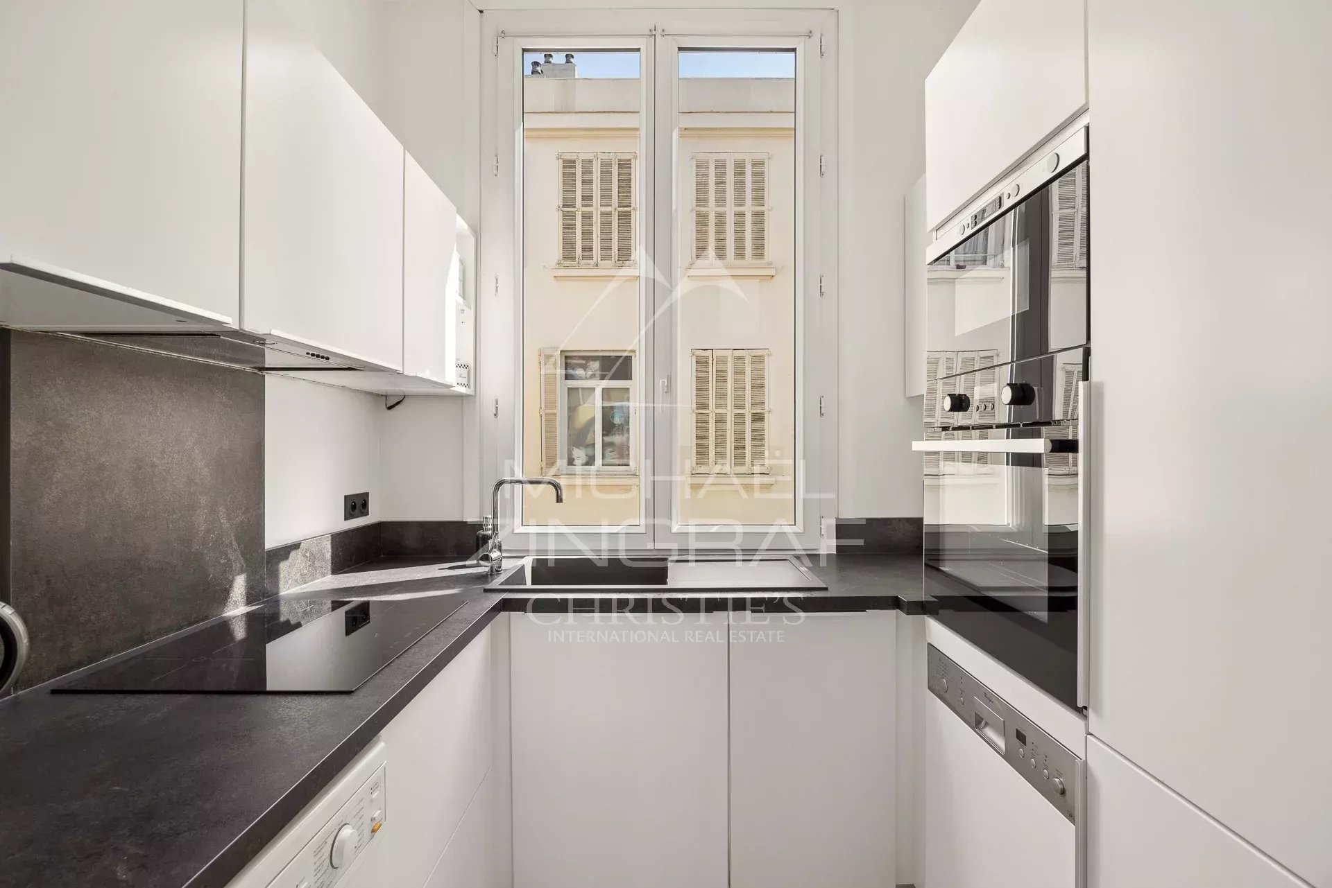 Cuisine d’un appartement T4 à Cannes Cuisine moderne et lumineuse d'un appartement T4 à Cannes, avec fenêtres donnant sur l'extérieur.