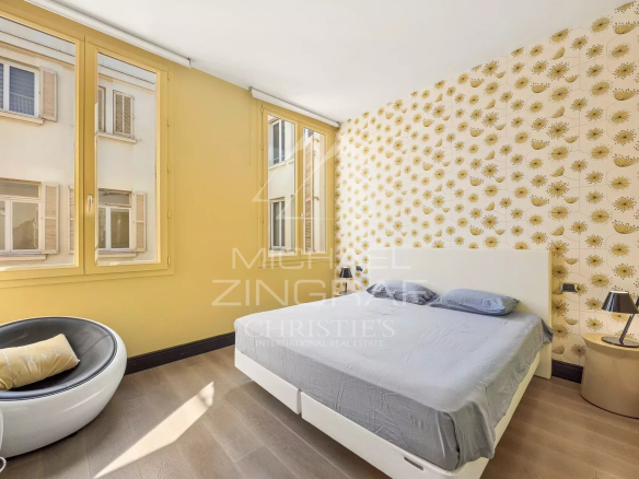 Chambre d'un appartement T4 à Cannes avec murs jaunes et fenêtre lumineuse.