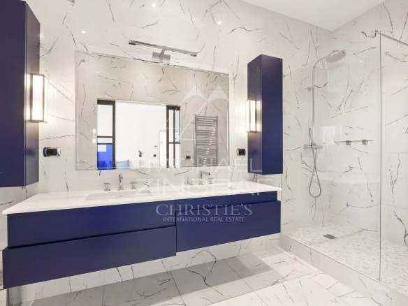 Salle de bain moderne avec lavabo et douche à l'italienne, murs en marbre blanc et bleu.