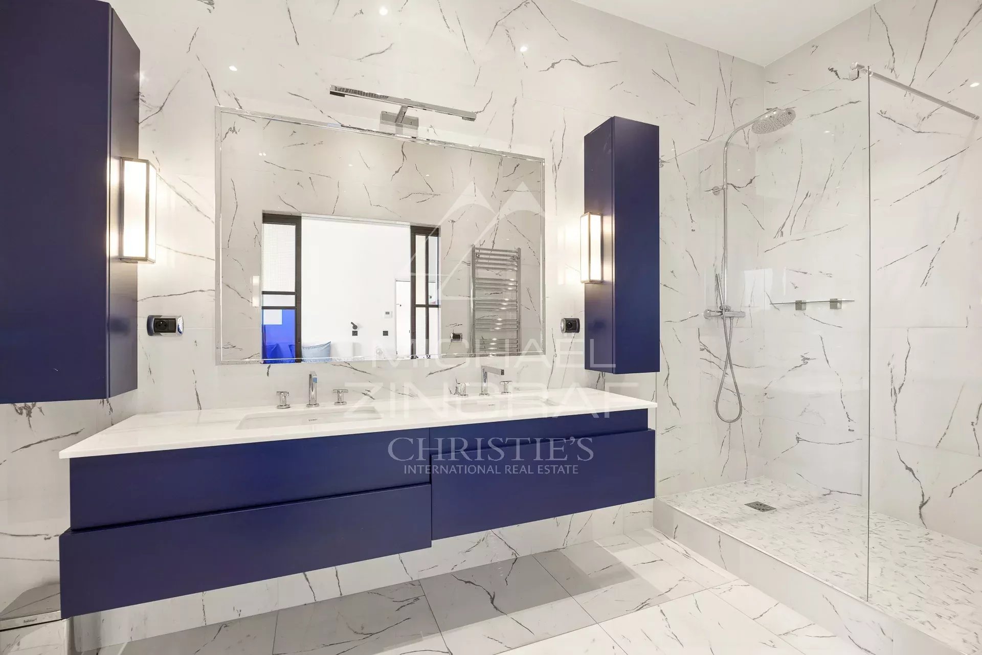 Salle de bain moderne de l’appartement T4 à Cannes Salle de bain moderne avec lavabo et douche à l'italienne, murs en marbre blanc et bleu.